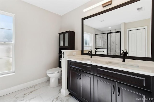 bathroom with vanity, plenty of natural light, a shower with door, and toilet