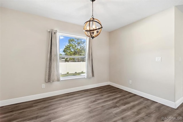 unfurnished room with dark hardwood / wood-style flooring, a wealth of natural light, and a chandelier