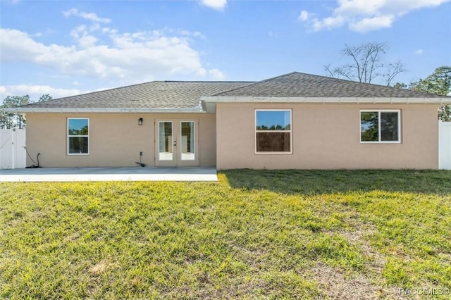 back of property featuring french doors, a patio, and a lawn