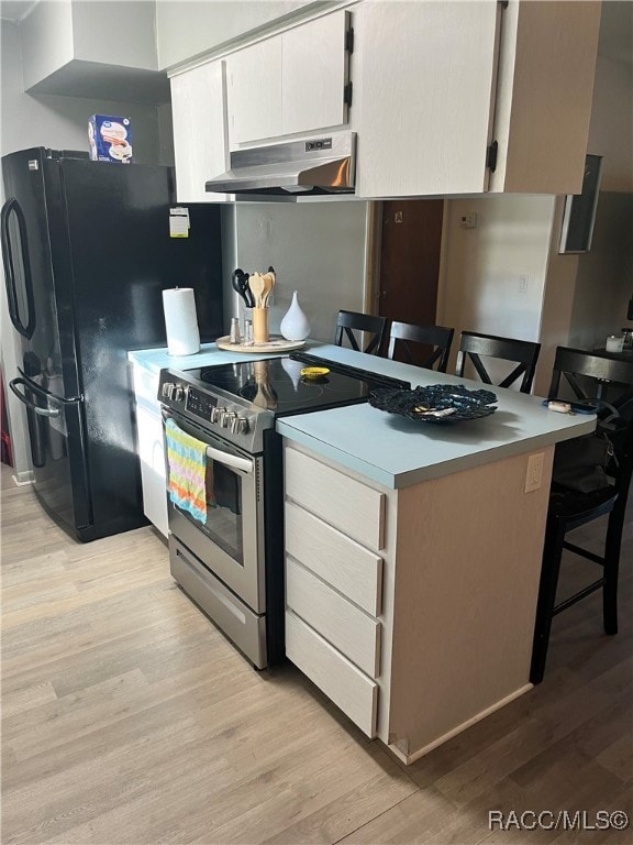 kitchen with white cabinets, light wood-type flooring, a kitchen bar, and stainless steel electric range oven