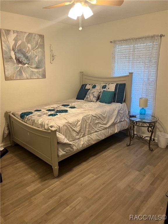 bedroom with ceiling fan and hardwood / wood-style flooring