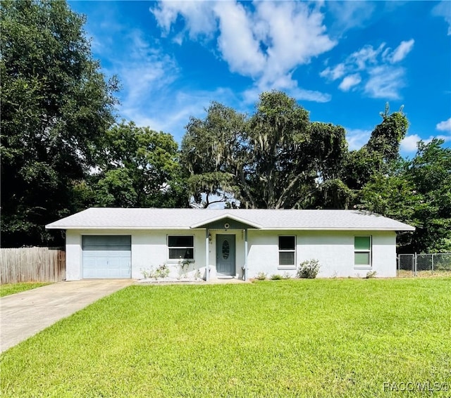 ranch-style home with a garage and a front lawn