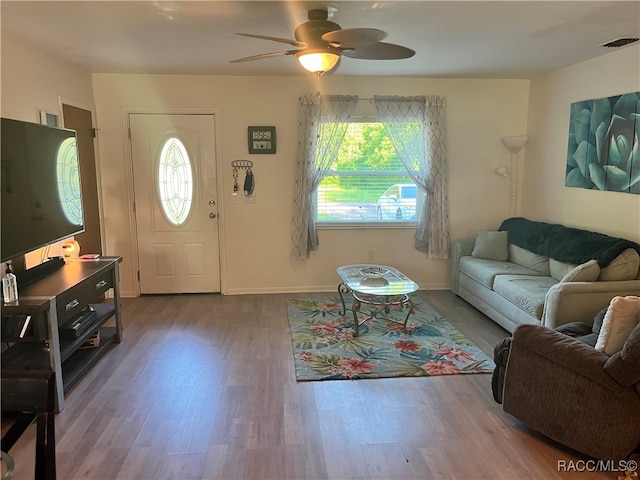 living room featuring ceiling fan and hardwood / wood-style flooring