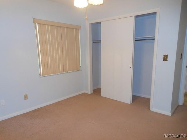 unfurnished bedroom with carpet, baseboards, and a closet