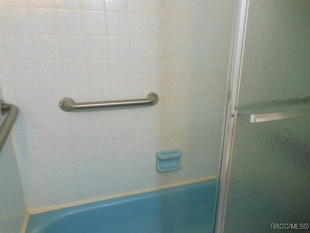 bathroom with a shower with door and a bathtub
