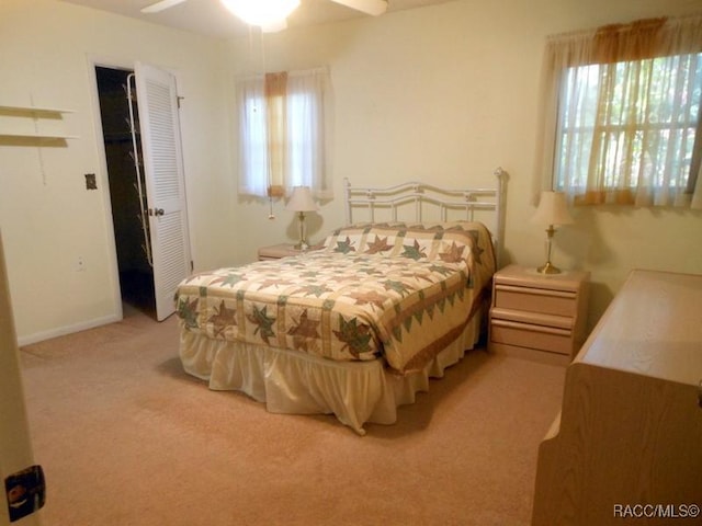 bedroom with a ceiling fan and light carpet