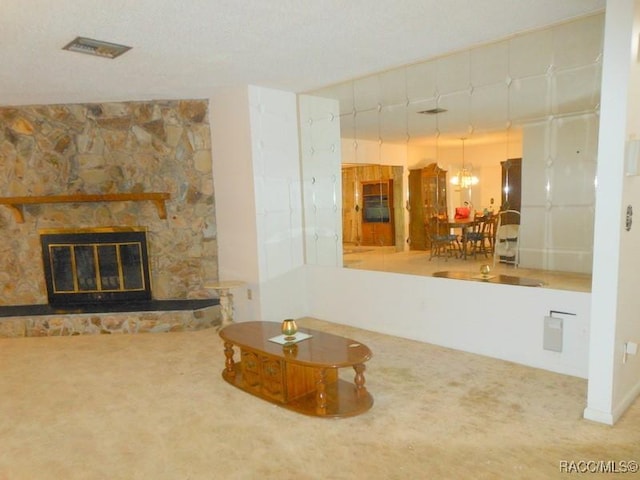 carpeted living room featuring visible vents, a chandelier, and a fireplace