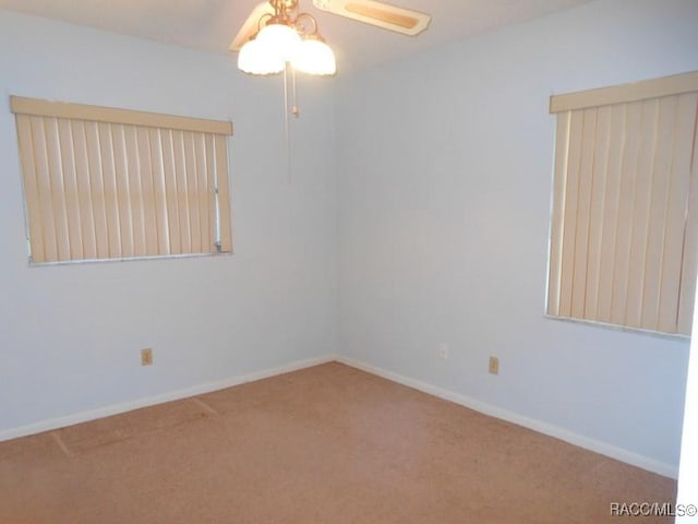 spare room with carpet flooring, ceiling fan, and baseboards