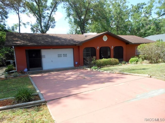 single story home with stucco siding, concrete driveway, and an attached garage