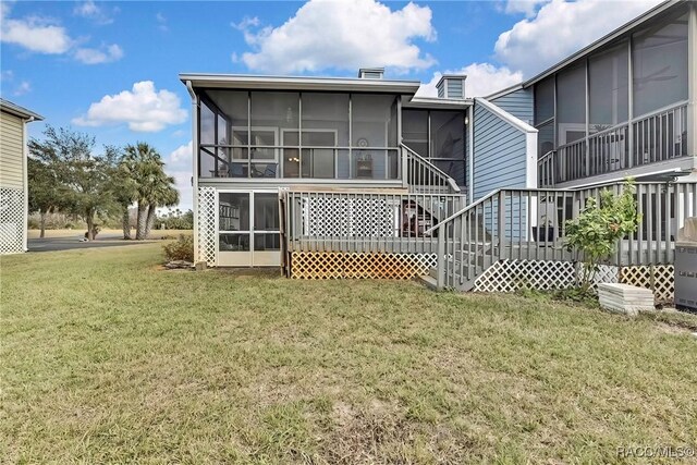 2891 N Rivers Edge Blvd Unit 100, Crystal River, FL 34429 - rear view of property featuring a sunroom and a lawn