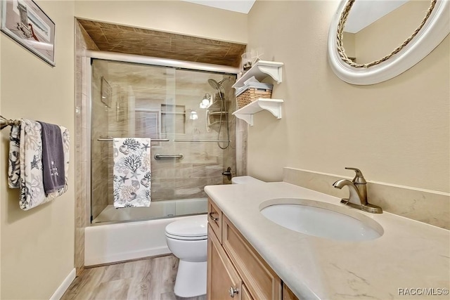 2891 N Rivers Edge Blvd Unit 100, Crystal River, FL 34429 - bathroom featuring toilet, bath / shower combo with glass door, vanity, and wood finished floors