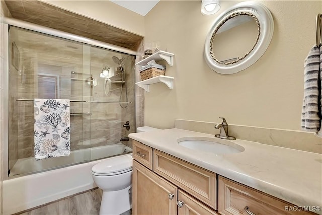 2891 N Rivers Edge Blvd Unit 100, Crystal River, FL 34429 - full bath with toilet, bath / shower combo with glass door, vanity, and wood finished floors