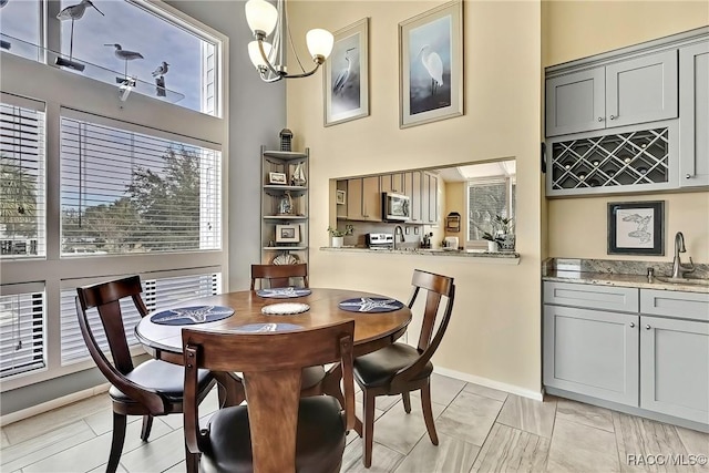 2891 N Rivers Edge Blvd Unit 100, Crystal River, FL 34429 - dining space featuring a chandelier, a towering ceiling, and baseboards