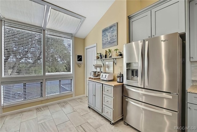 2891 N Rivers Edge Blvd Unit 100, Crystal River, FL 34429 - kitchen with stainless steel fridge with ice dispenser, gray cabinets, lofted ceiling, baseboards, and open shelves