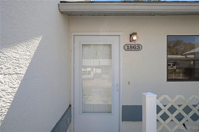 entrance to property with stucco siding