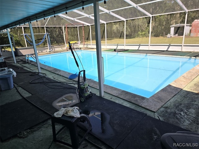 view of pool with glass enclosure and a patio area