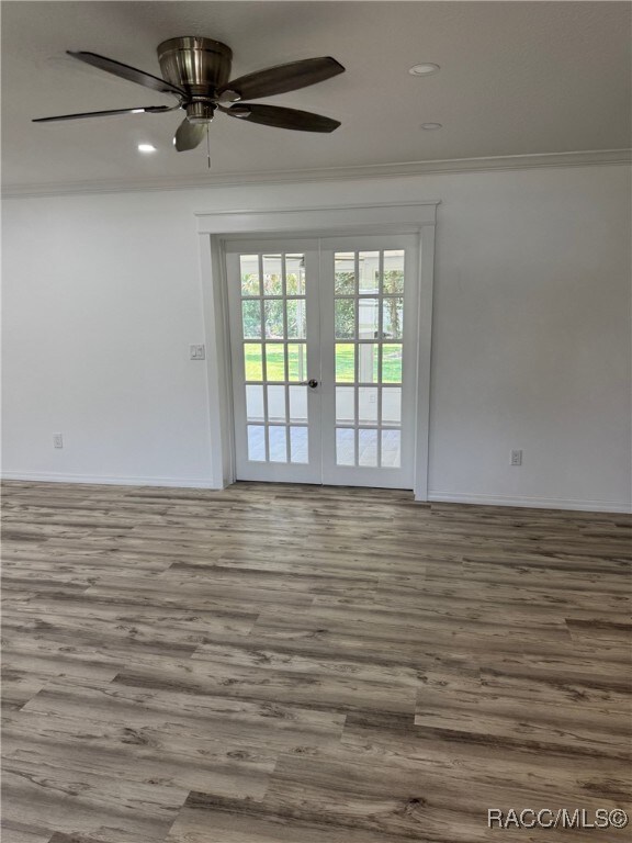 1464 NW 22nd St, Crystal River, FL 34428 - spare room featuring french doors, wood finished floors, crown molding, baseboards, and recessed lighting