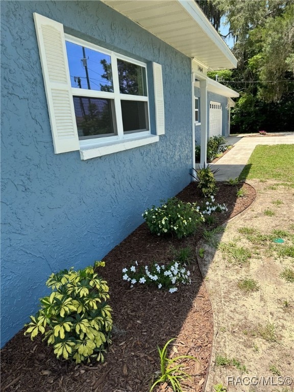 1464 NW 22nd St, Crystal River, FL 34428 - view of home's exterior featuring stucco siding and a garage