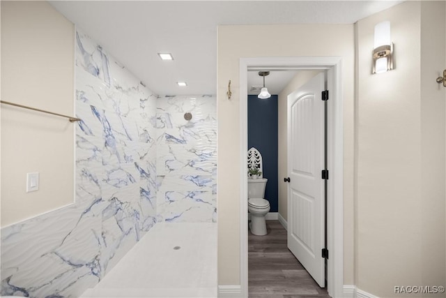 bathroom featuring toilet, wood-type flooring, and a shower