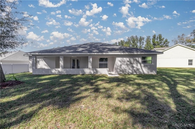 back of property featuring a yard