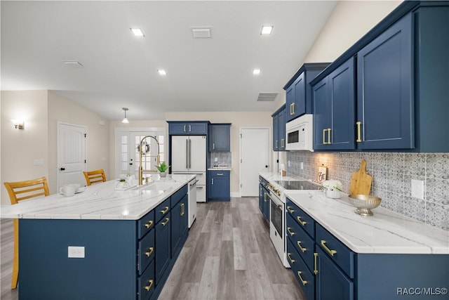 kitchen with a spacious island, decorative backsplash, sink, white appliances, and a breakfast bar area