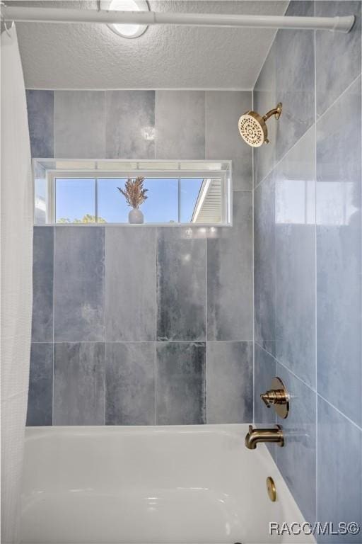 bathroom featuring a textured ceiling and shower / bath combo