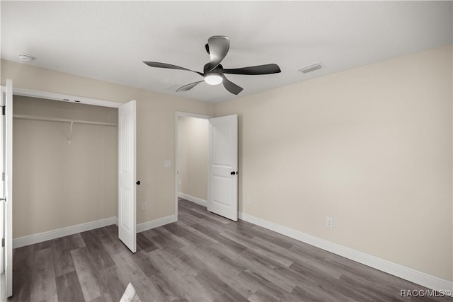 unfurnished bedroom featuring ceiling fan, a closet, and hardwood / wood-style floors