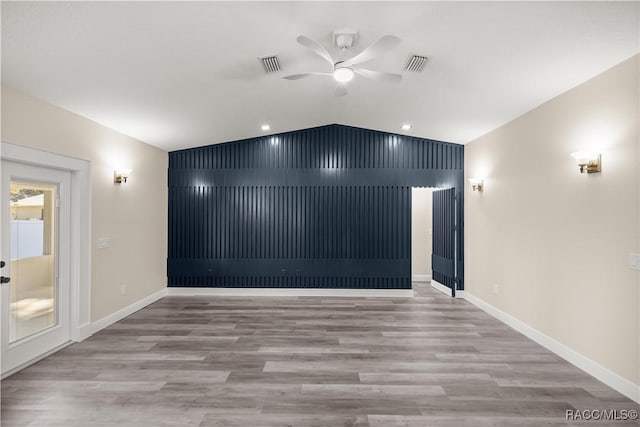 unfurnished room with light wood-type flooring, ceiling fan, and vaulted ceiling