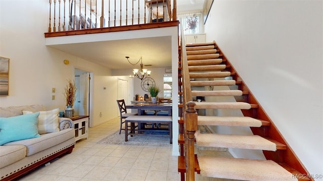 staircase with a chandelier, a high ceiling, tile patterned floors, and visible vents