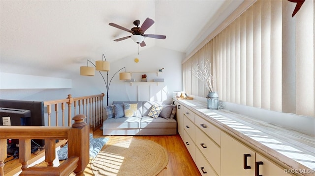 interior space featuring ceiling fan, light wood finished floors, and lofted ceiling