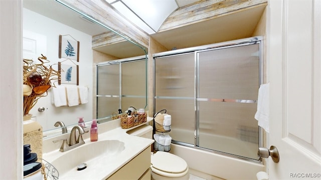 full bathroom featuring vanity, combined bath / shower with glass door, and toilet