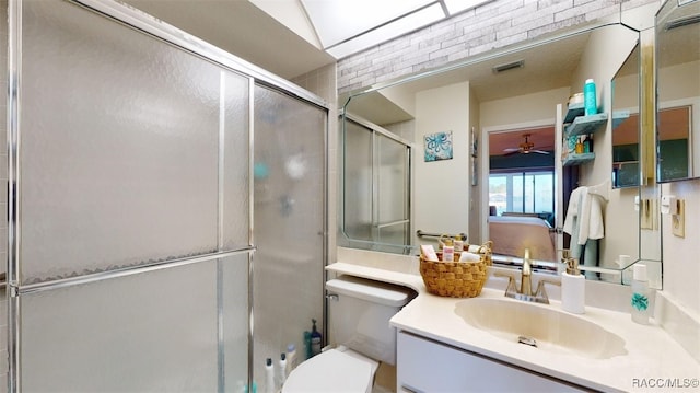 bathroom featuring vanity, a shower with shower door, and toilet