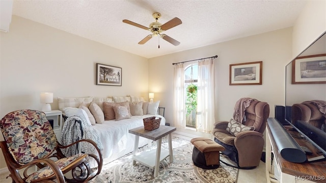 living room with ceiling fan and a textured ceiling