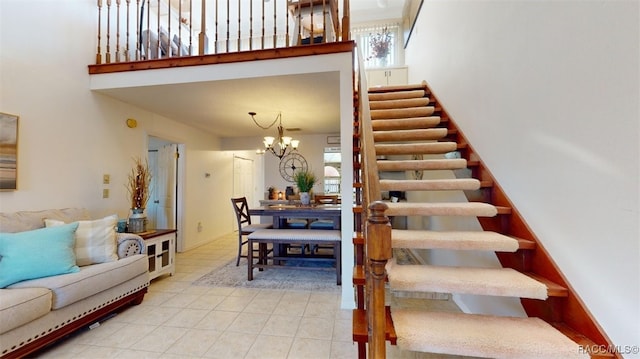 stairs with a high ceiling, tile patterned floors, and a notable chandelier