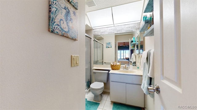 bathroom with visible vents, toilet, vanity, tile patterned flooring, and a stall shower