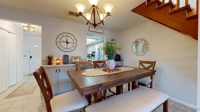 dining room with light tile patterned floors and a notable chandelier