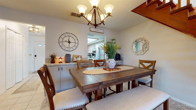 dining space with baseboards, a notable chandelier, visible vents, and stairway