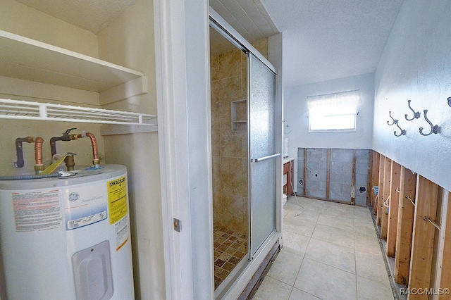 bathroom with electric water heater, tile patterned flooring, a shower with shower door, and a textured ceiling