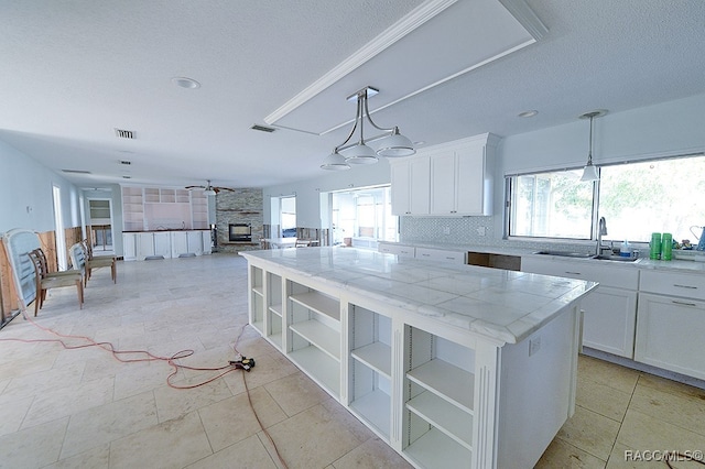 kitchen with white cabinets, sink, and a wealth of natural light