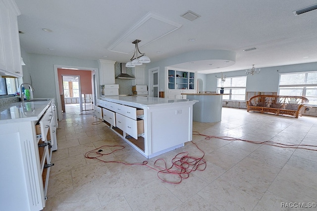 kitchen with a wealth of natural light, white cabinetry, and a center island