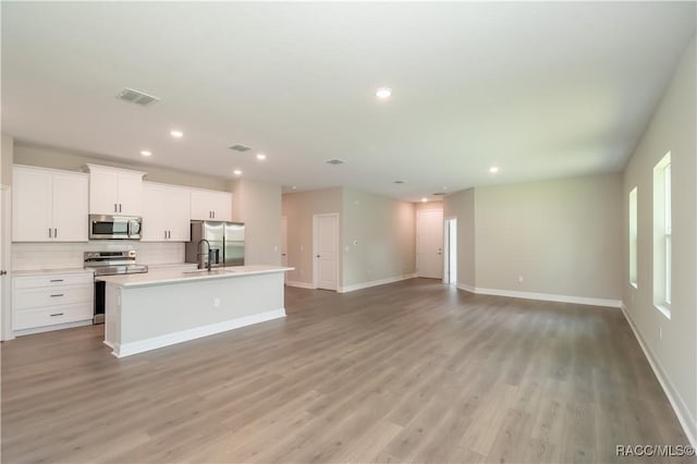 9262 N Alpinia Dr, Citrus Springs, FL 34434 - unfurnished living room featuring recessed lighting, light wood-style flooring, baseboards, and a sink
