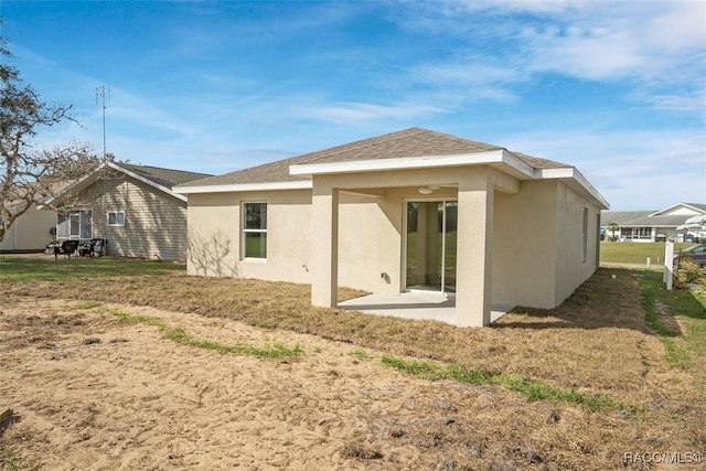 rear view of property featuring a patio and stucco siding