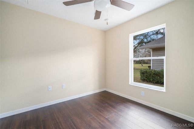 unfurnished room with dark wood-style flooring, a ceiling fan, and baseboards