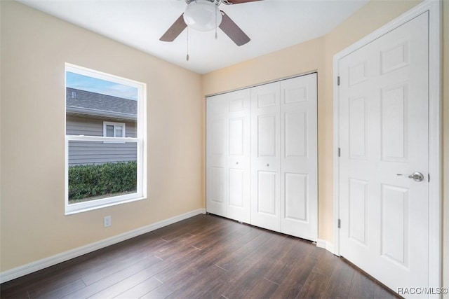 unfurnished bedroom featuring ceiling fan, a closet, dark wood finished floors, and baseboards