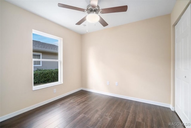 unfurnished room with ceiling fan, dark wood-style flooring, a wealth of natural light, and baseboards