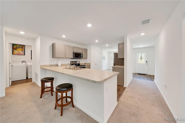 1435 W Adele Ct, Citrus Springs, FL 34434 - kitchen featuring light colored carpet, stainless steel appliances, washing machine and clothes dryer, light countertops, and gray cabinets