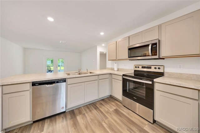 1435 W Adele Ct, Citrus Springs, FL 34434 - kitchen featuring appliances with stainless steel finishes, a sink, a peninsula, light countertops, and light wood finished floors