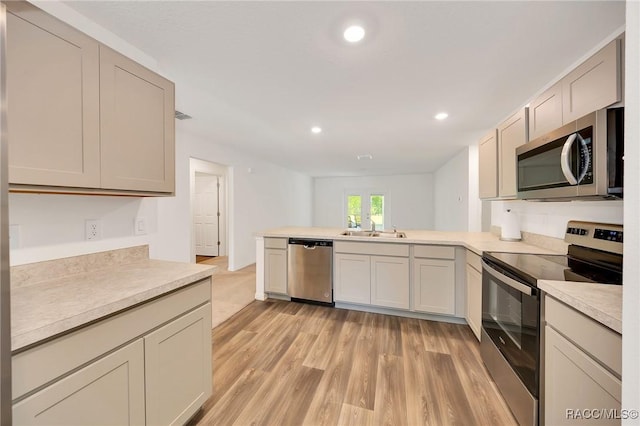 1435 W Adele Ct, Citrus Springs, FL 34434 - kitchen featuring stainless steel appliances, a sink, a peninsula, light countertops, and light wood-style floors