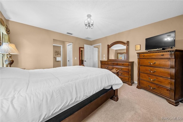 bedroom with light carpet, visible vents, and a notable chandelier