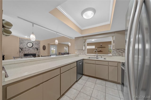 kitchen featuring a sink, a tray ceiling, backsplash, appliances with stainless steel finishes, and light countertops